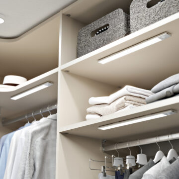 Interior of a built-in wardrobe with shelves and battery-powered lighting.