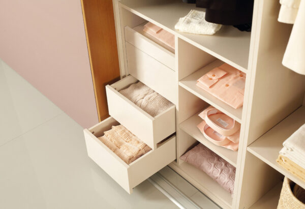Interior of a built-in wardrobe with push-to-open drawers and a pull-out shelf.